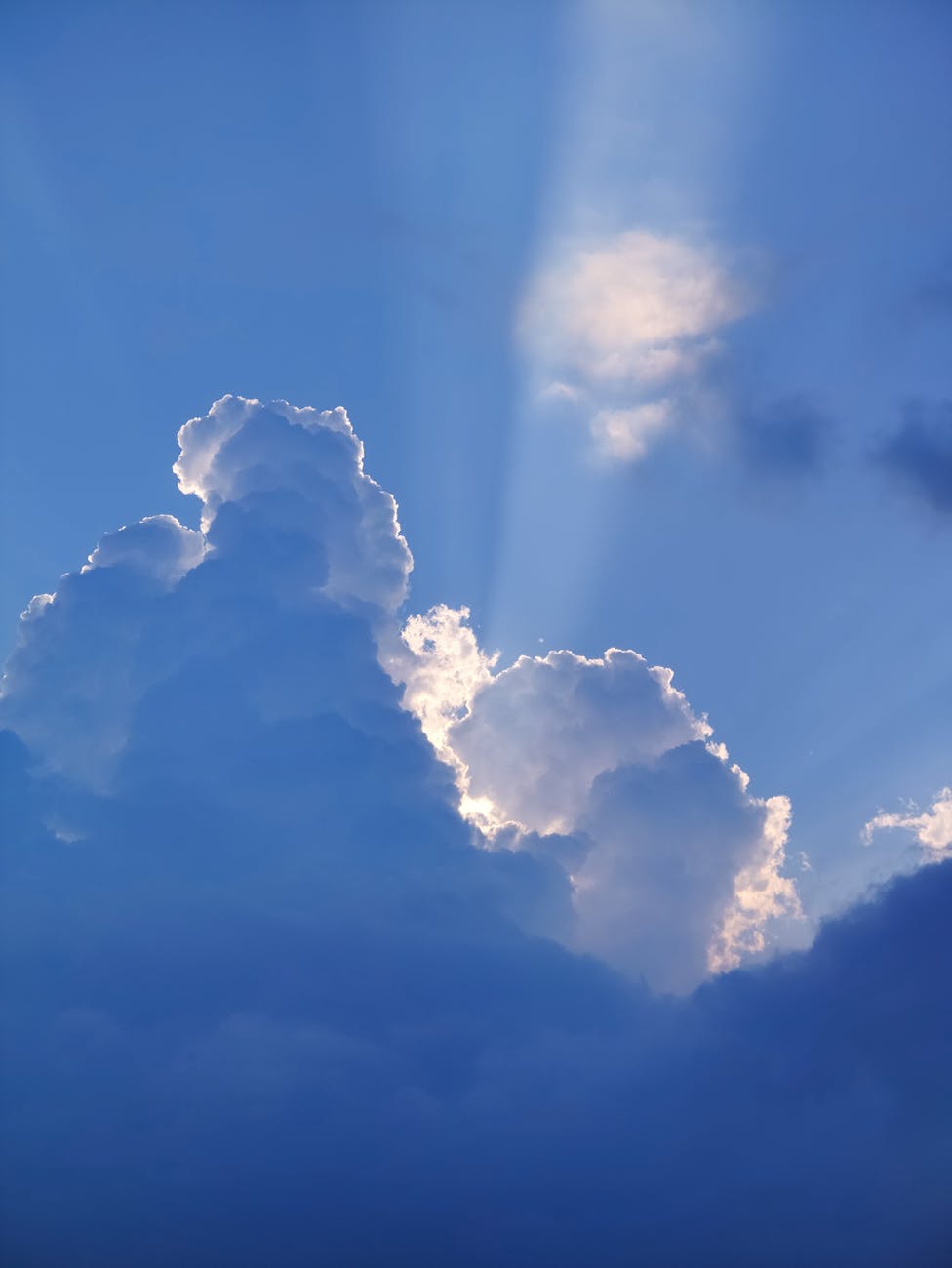 dramatic clouds with sun rays in blue sky